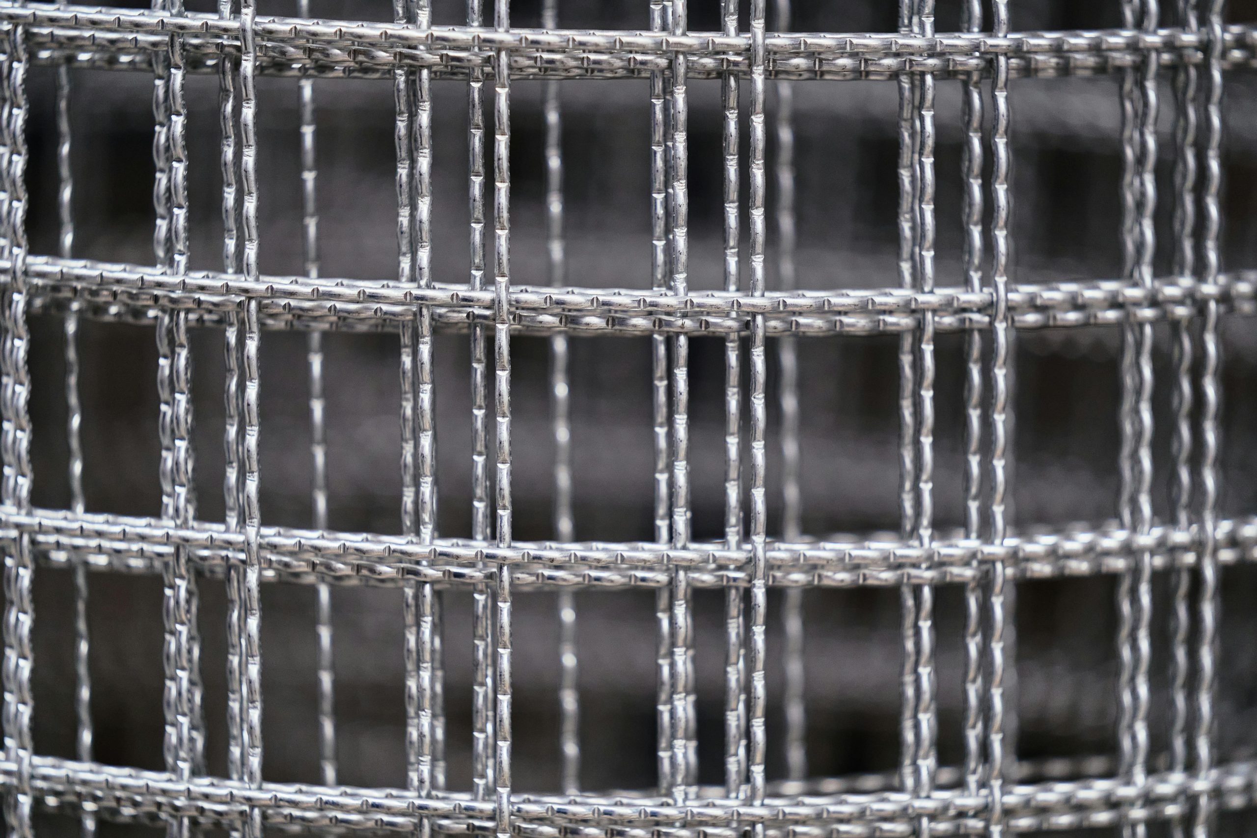 High-resolution close-up of a metal wire mesh grid, showcasing industrial texture and design.